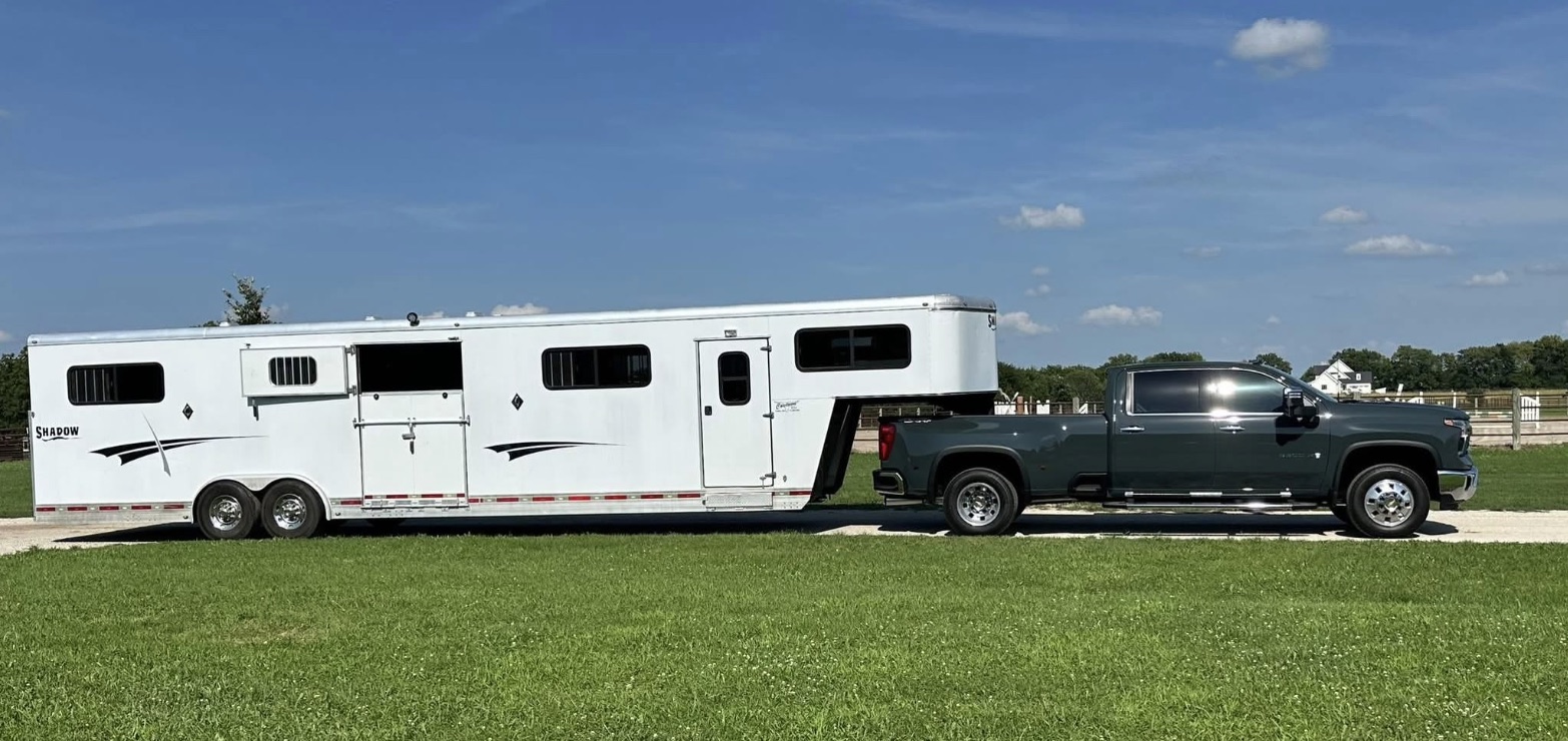 The GW Equestrian rig parked on grass under a blue sky